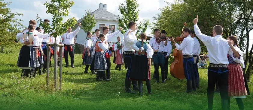Folklorní soubory s cimbálovou muzikou před usedlostí skanzenu Rochus