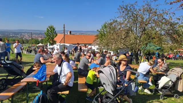 Plné lavice a stoly pod stromy na festivalu chutí a vůní